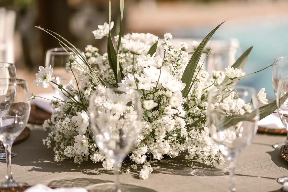 Mesa posta com arranjo de flores brancas